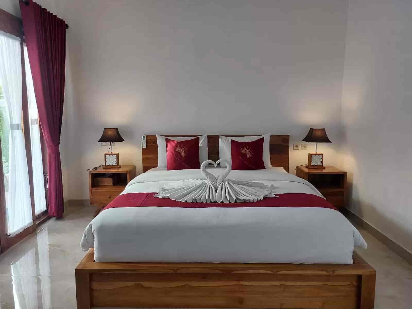 Queen room with wooden furniture and red accent pillows