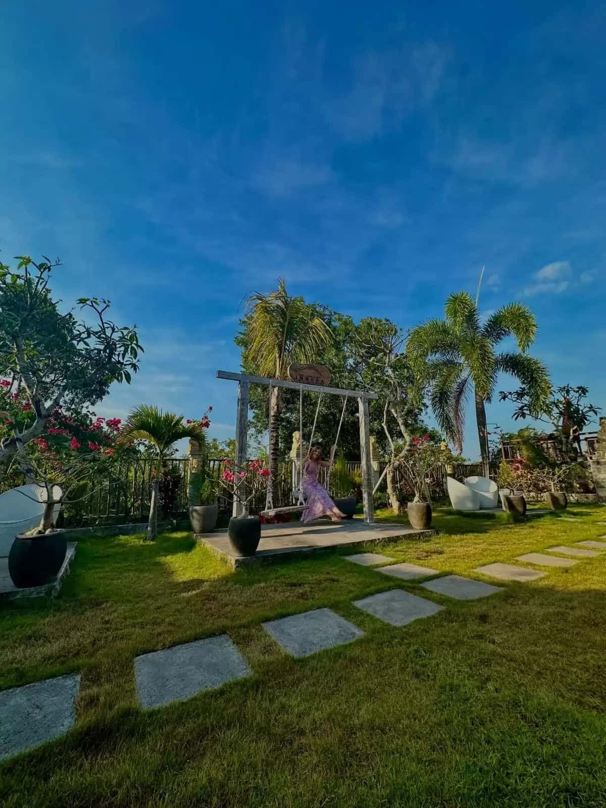 Wide view of the resort garden with swing and tropical trees
